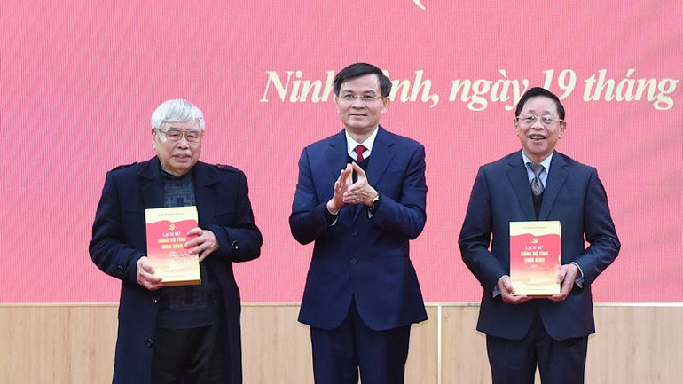 Đồng chí Đoàn Minh Huấn, Ủy viên Trung ương Đảng, Bí thư Tỉnh ủy Ninh Bình trao tặng bộ sách cho các đồng chí nguyên là lãnh đạo tỉnh Ninh Bình. (Ảnh: XUÂN TRƯỜNG)