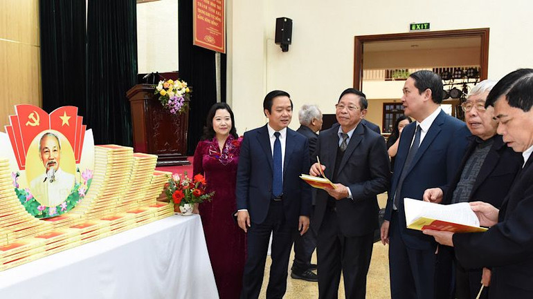 Các đại biểu tham quan trưng bày bộ sách. (Ảnh: XUÂN TRƯỜNG)