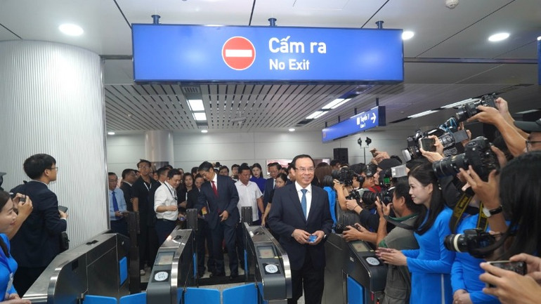 Bí thư Thành ủy Thành phố Hồ Chí Minh Nguyễn Văn Nên dùng thẻ đi metro lên chuyến tàu lăn bánh sáng 22/12. (Ảnh: THẾ ANH)