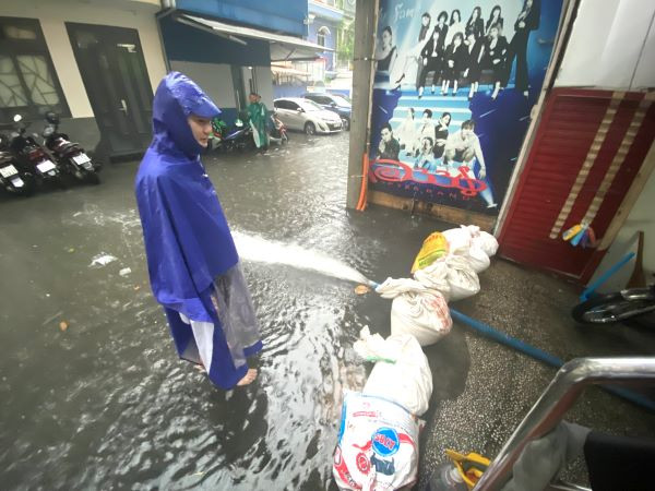 Người dân ở một tuyến hẻm trên đường Nguyễn Thị Minh Khai, quận 1 dùng bao chắn cát và máy bơm để "chống ngập".