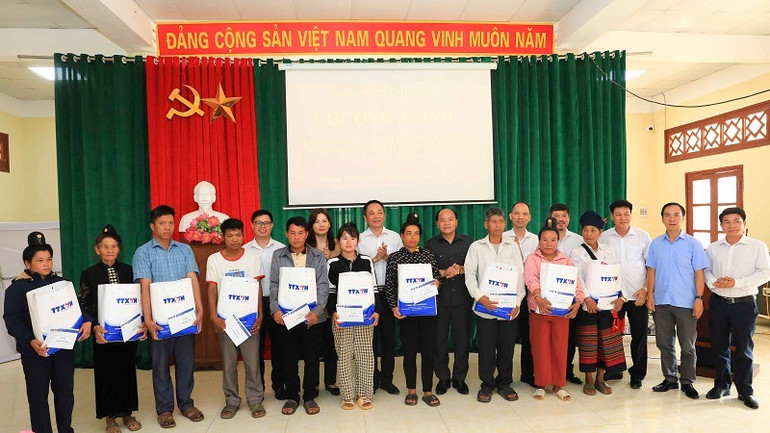 Các đồng chí trong đoàn công tác Thông tấn xã Việt Nam và ông Đào Hoài Nam, Phó Chủ tịch Ủy ban nhân dân thành phố Điện Biên Phủ, trao quà đến các gia đình nghèo.