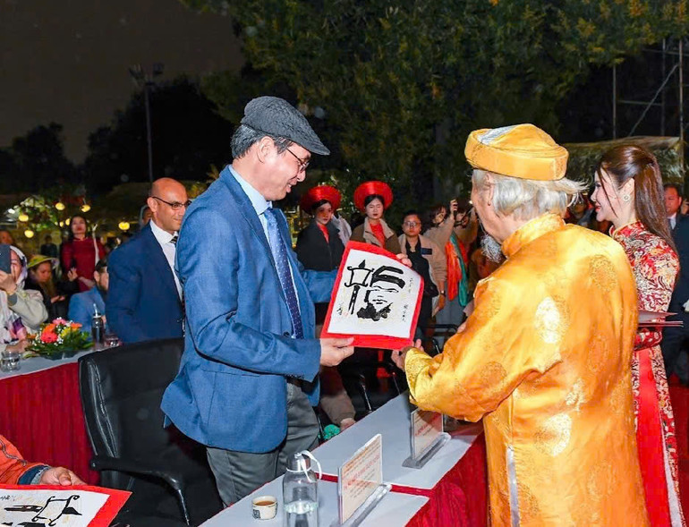 Tặng thư pháp viết theo lối Nhân diện thư cho đại biểu dự sự kiện tại Hoàng thành Thăng Long