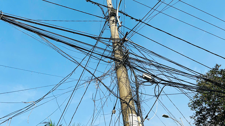 Dây điện, dây cáp viễn thông giăng mắc chằng chịt; nhiều dây cáp treo trên cột gây quá tải