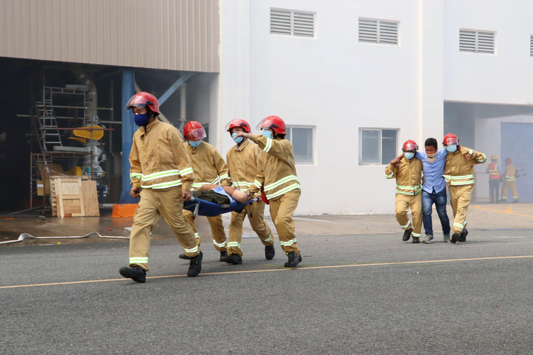 Lực lượng cứu hộ đưa các công nhân mắc kẹt bên trong nhà máy ra bên ngoài.