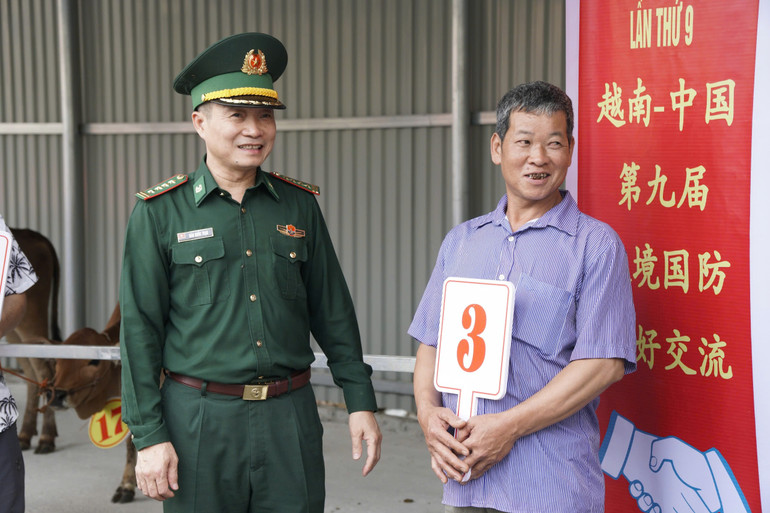 Đại tá Đào Quốc Thạo, Chỉ huy trưởng Bộ đội Biên phòng Lạng Sơn, chia sẻ niềm vui với bà con được nhận bò giống.