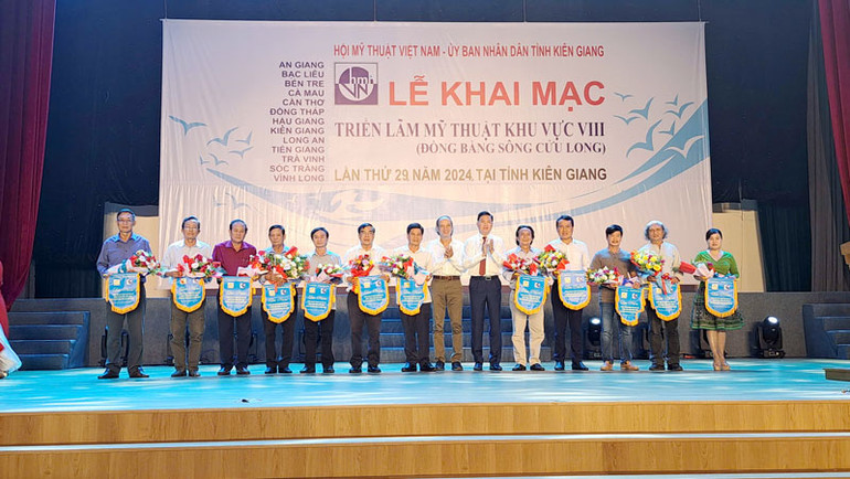 Ban tổ chức trao cờ lưu niệm và hoa cho đại diện các Hội Văn học Nghệ thuật khu vực đồng bằng sông Cửu Long. Ban tổ chức trao cờ lưu niệm và hoa cho đại diện các Hội Văn học Nghệ thuật khu vực đồng bằng sông Cửu Long.