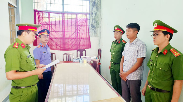 Điều tra viên tống đạt lệnh bắt tạm giam 4 tháng đối với Lê Minh Điệp (áo sơ mi sọc), giám đốc Công ty trách nhiệm hữu hạn tư vấn đầu tư và phát triển LHĐ. (Ảnh: VĂN VŨ)