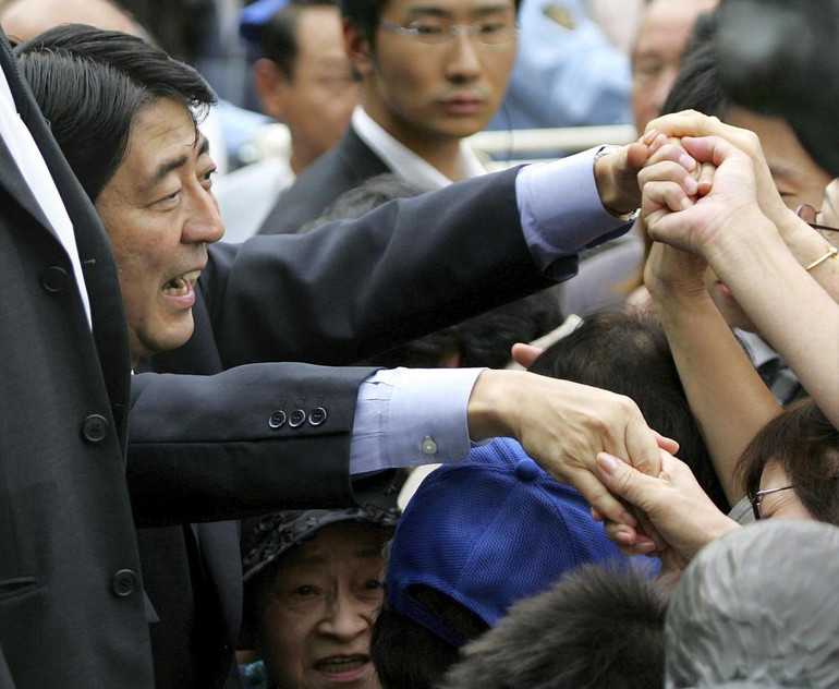 Chánh Văn phòng Nội các Nhật Bản Abe Shinzo bắt tay người ủng hộ trong lúc ông có bài phát biểu trước công chúng tại nhà ga Shibuya, ngày 16/9/2006. (Ảnh: AP) ẢNH -0