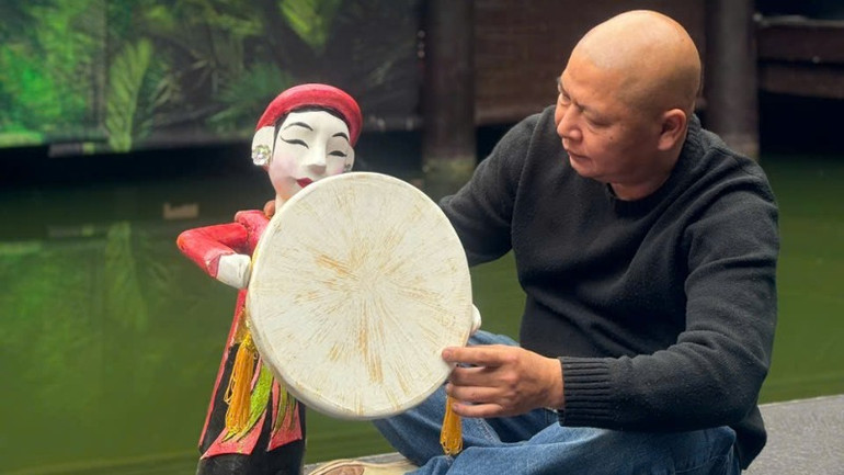 Nghệ sĩ ưu tú Vũ Thế Khiển bên một tác phẩm do ông chế tác.