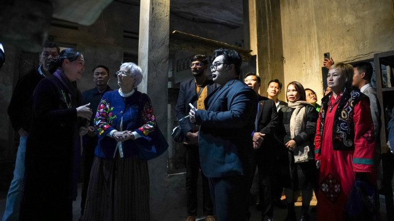 Nghệ nhân Hà Thị Vinh (thứ hai từ trái sang) niềm nở đón tiếp khách tham quan.