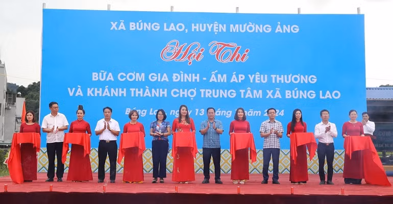 Các đồng chí lãnh đạo huyện Mường Ảng và lãnh đạo các sở, ngành tỉnh Điện Biên cắt băng khai mạc hội thi "Bữa cơm gia đình-ấm áp yêu thương" đánh dấu sự kiện đưa chợ trung tâm Búng Lao vào sử dụng.