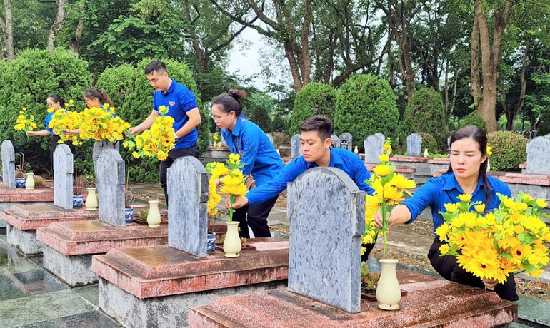 Đoàn viên thanh niên tỉnh Điện Biên thay mới các lọ hoa trên từng phần mộ liệt sĩ tại Nghĩa trang liệt sĩ Độc Lập.