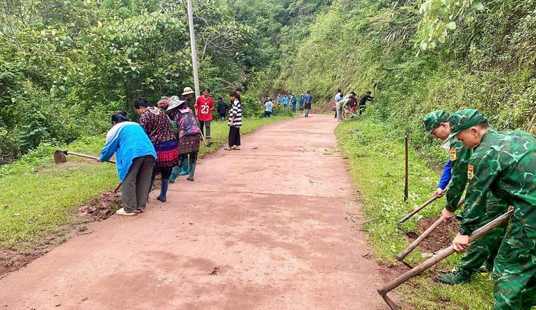 Cán bộ, chiến sĩ Đồn biên phòng Nà Bủng giúp nhân dân xã Nà Bủng thu dọn vệ sinh đường vào bản.