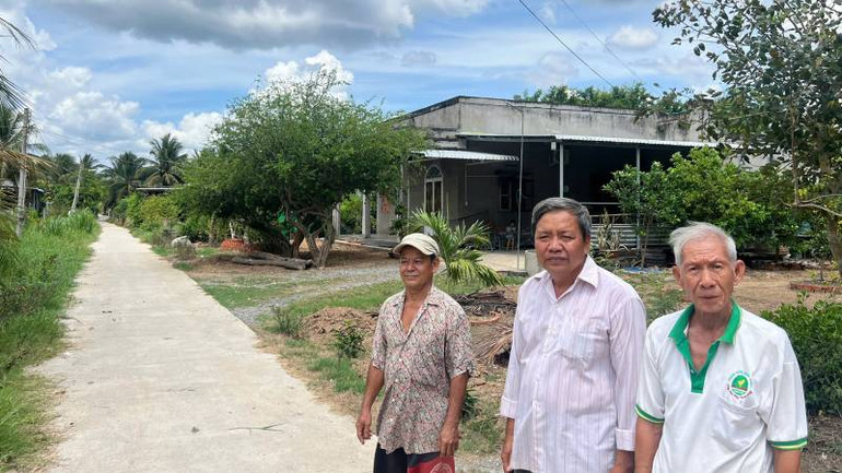 Ông Đặng Văn Sơn (giữa) là gương điển hình tích cực vận động nhân dân hiến đất, vật tư làm đường giao thông nông thôn tại địa phương. (Ảnh: HOÀNG TRUNG)