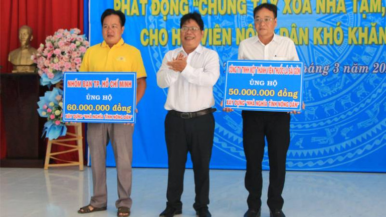 Mạnh thường quân trao bảng tượng trưng ủng hộ tại Chương trình phát động chung tay xóa nhà tạm, nhà dột nát. (Ảnh: HOÀNG TRUNG)