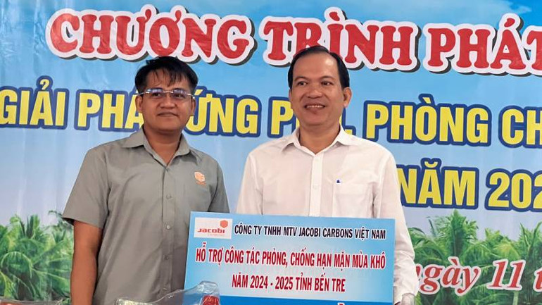 Đại diện Công ty Trách nhiệm hữu hạn Một thành viên JACOBI CARBONS Việt Nam trao bảng tượng trưng hỗ trợ công tác phòng, chống hạn mặn tại tỉnh Bến Tre. (Ảnh: HOÀNG TRUNG)