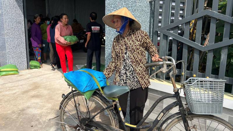 Hộ gia đình chính sách, gia đình có hoàn cảnh khó khăn đến nhận quà. (Ảnh: HOÀNG TRUNG)