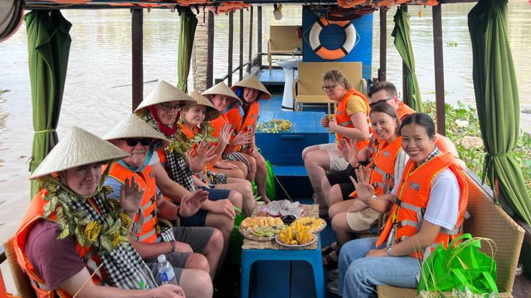 Đoàn khách du lịch quốc tế trải nghiệm du ngoạn bằng tàu trên sông Bến Tre. (Ảnh: HOÀNG TRUNG)