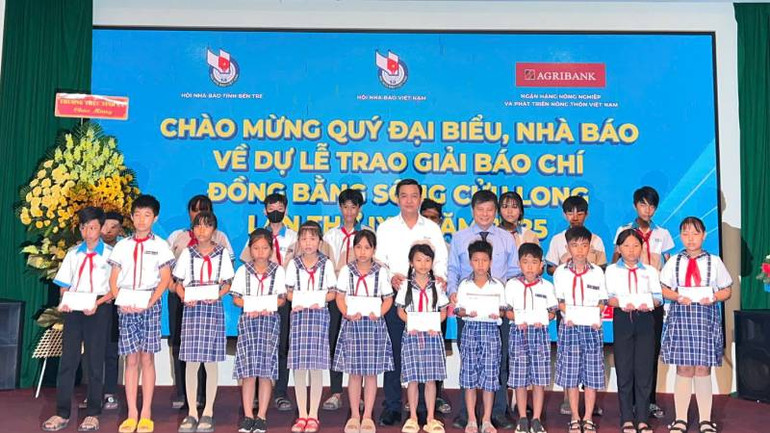 Đại diện Báo Người lao động trao học bổng cho các học sinh có hoàn cảnh khó khăn. (Ảnh: HOÀNG TRUNG)