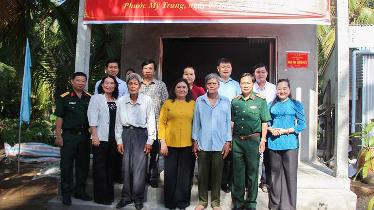 Đại diện lãnh đạo Bộ Quốc phòng cùng chính quyền địa phương bàn giao căn nhà tình thương cho hộ dân tại huyện Mỏ Cày Bắc. (Ảnh: HOÀNG TRUNG)