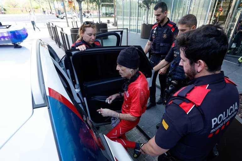 Cảnh sát bắt giữ "người nhện" Pháp Alain Robert sau khi ông leo lên tòa nhà ngày 5/5. Ảnh: Reuters