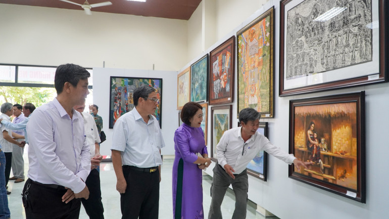 Các đại biểu dự khai mạc triển lãm tham quan, thưởng lãm các tác phẩm được trưng bày tại triển lãm.