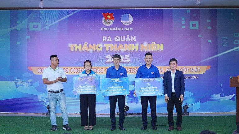 Ông Lê Quang Quỳnh, Phó Trưởng Ban Tuyên giáo và Dân vận Tỉnh ủy Quảng Nam và đại diện nhà tài trợ trao bảng tượng trưng hỗ trợ 50 tấn xi-măng, 50 nghìn viên gạch cùng 300 thùng sữa cho đại diện Tỉnh đoàn và Huyện đoàn Đông Giang.