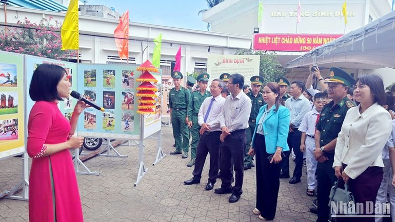 Các đại biểu tham dự triển lãm nghe hướng dẫn viên giới thiệu văn hóa Bình Định.