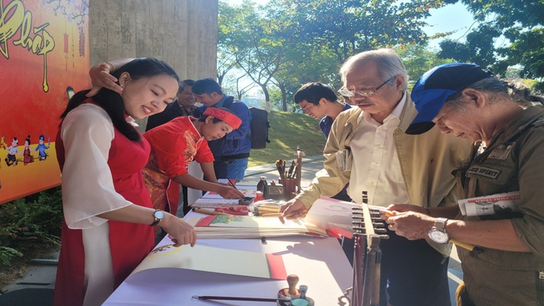 Tặng chữ thư pháp đầu năm tại hội báo xuân.