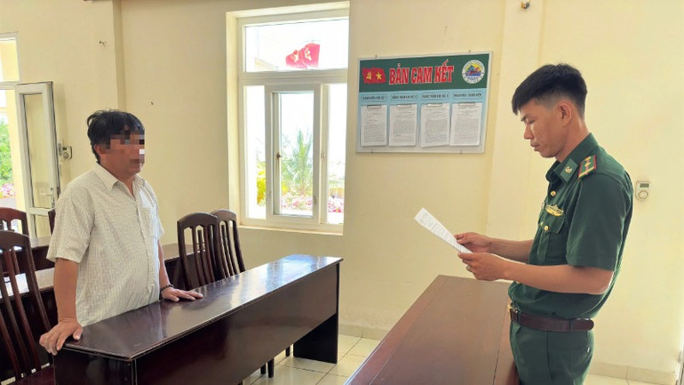 Cán bộ Đồn Biên phòng Mỹ An đọc quyết định xử phạt vi phạm hành chính chủ tàu cá vi phạm.