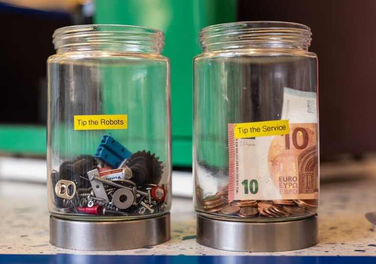 Hộp đựng tiền tip cho robot và người phục vụ tại nhà hàng. Ảnh: Reuters.