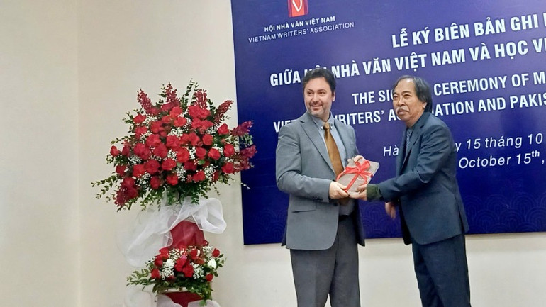 Chủ tịch Hội Nhà văn Việt Nam Nguyễn Quang Thiều (phải) tặng quà cho phía Pakistan.