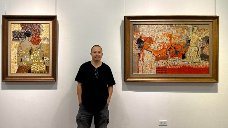 Họa sĩ Nguyễn Văn Đức bên các tác phẩm tại triển lãm.