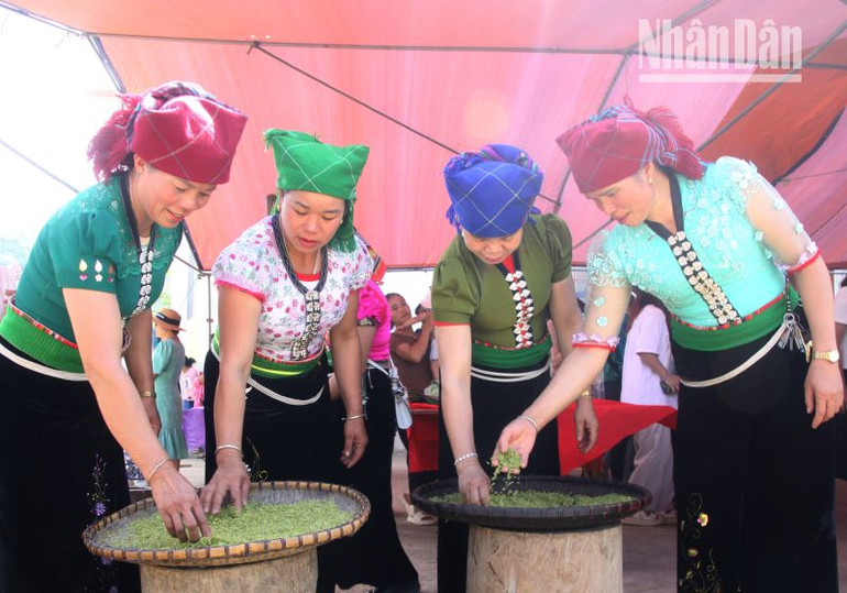 Phụ nữ dân tộc Thái, bản Nà Tâu, xã Ngọc Chiến tham gia phần thi giã và chế biến cốm.