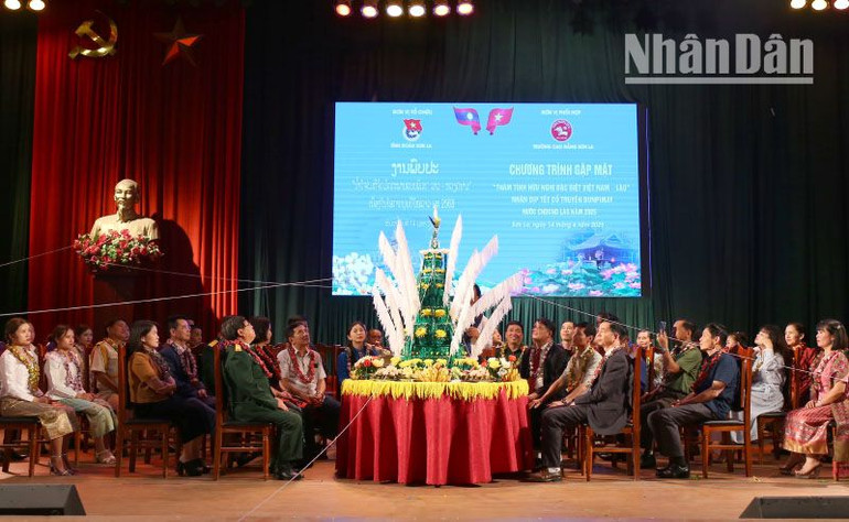 Thực hiện nghi lễ buộc chỉ cổ tay tại chương trình gặp mặt lưu học sinh Lào nhân dịp Tết cổ truyền Bunpimay của nước bạn Lào.