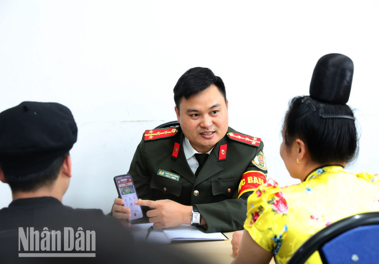 Đại úy Trần Văn Thắng, Công an xã Mường Sai, huyện biên giới Sông Mã đang hướng dẫn người dân cài đặt tài khoản VNeID.