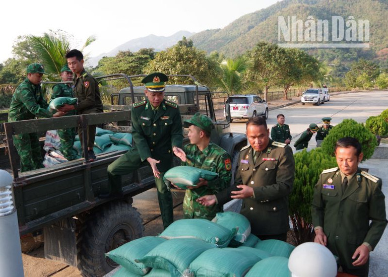 Cán bộ, chiến sĩ Đồn Biên phòng Cửa khẩu Chiềng Khương giúp chuyển gạo tới các Đại đội Biên phòng 211, 212, 213 của Bộ Chỉ huy Quân sự tỉnh Houaphanh.