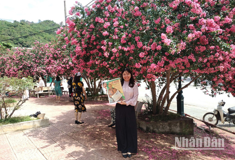 Một bạn đọc lưu giữ khoảnh khắc đẹp bên hoa Tường Vi cùng ấn phẩm Nhân Dân Cuối tuần số 1890 kỷ niệm 135 năm Ngày sinh Chủ tịch Hồ Chí Minh - một con số đặc biệt ý nghĩa, mang tên “Lời Người-Lời của nước non”.