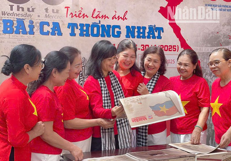 Khách tham quan triển lãm ảnh “Bài ca thống nhất” chào mừng kỷ niệm 50 năm Ngày Giải phóng miền nam, thống nhất đất nước cùng phụ san đặc biệt của Báo Nhân Dân tại Bảo tàng và Thư viện tỉnh Sơn La.