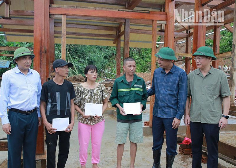 Đồng chí Thứ trưởng Nông nghiệp và Phát triển nông thôn hỗ trợ tiền cho các hộ bị thiên tai tại xã Hua Păng, huyện Mộc Châu.