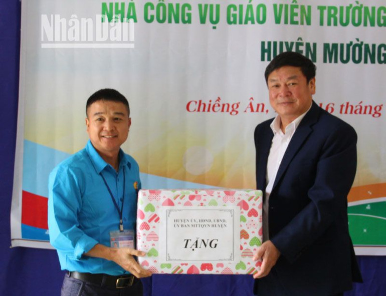 Bí thư huyện ủy Mường La tặng quà cho cán bộ, giáo viên trường tiểu học và trung học cơ sở Chiềng Ân. (Ảnh: Lam Giang)