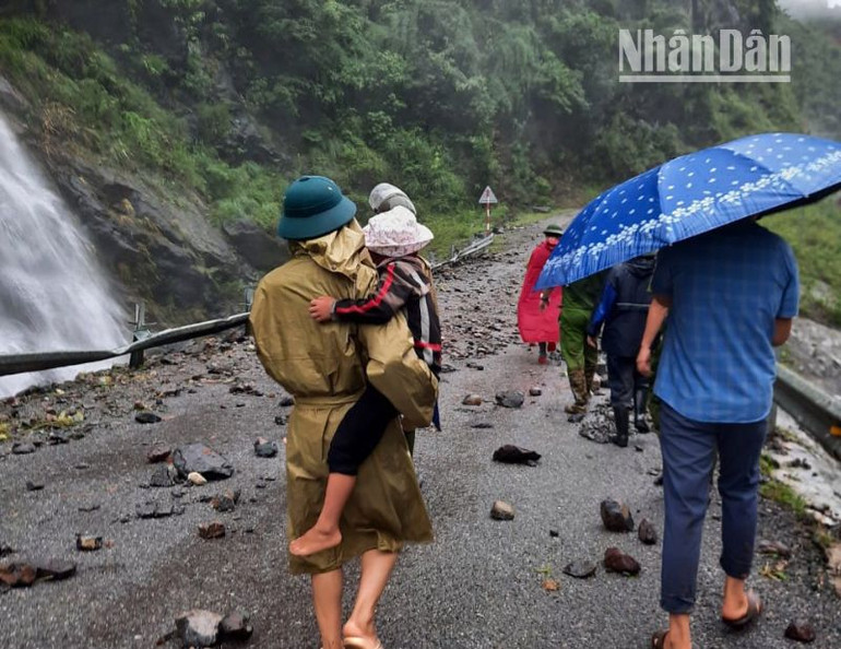 Lực lượng chức năng huyện Mường La hỗ trợ người dân di chuyển qua các khu vực bị sạt lở.