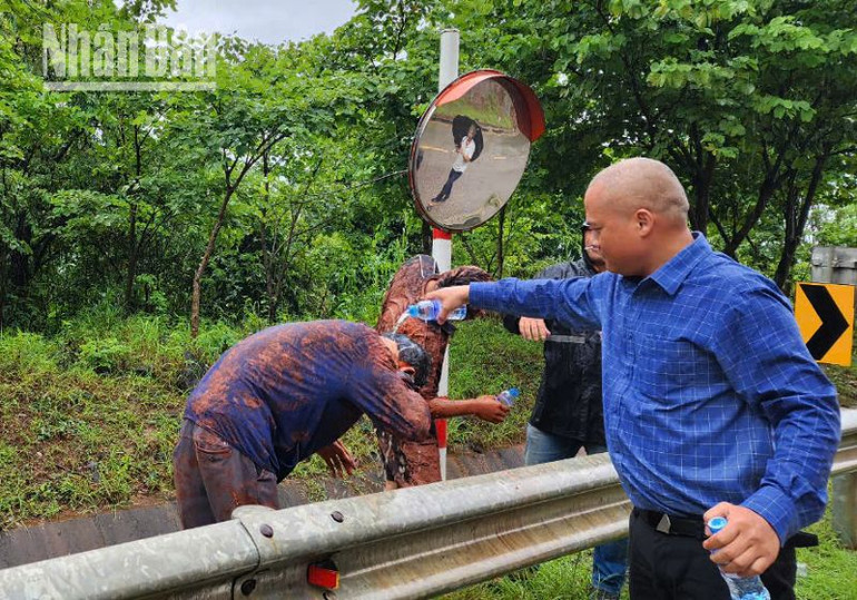 Người dân hỗ trợ, giúp những người trên 2 xe ô-tô bị sạt đất đá từ phía ta-luy dương trên tuyến quốc lộ 6. (Ảnh: NHẬT MINH)