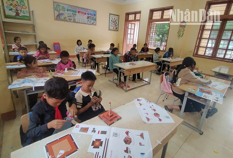 Các em học sinh dân tộc H'Mông và Thái tại tiểu học Co Mạ 2, huyện Thuận Châu đang hoàn thiện mô hình Cột cờ Hà Nội.