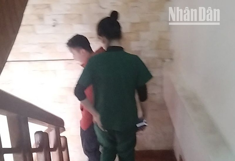 Một người đàn ông vừa điều trị xong ở khu vực tầng 3 của địa chỉ số 27 Tô Hiệu đang di chuyển cùng nhân viên điều trị xuống tầng 1 (ảnh cắt từ clip).