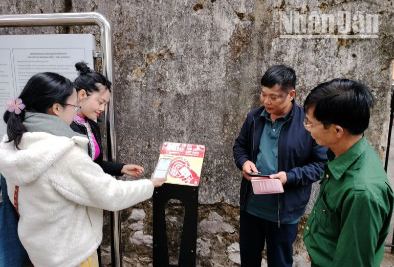 Chị Dương Ngọc Mai (ngoài cùng bên trái ảnh), đến từ Tân Phú, Bình Dương, đang trải nghiệm công nghệ số không dây trên bảng gắn chíp NFC được lắp đặt ngay cổng ra vào của Khu di tích quốc gia đặc biệt Nhà tù Sơn La. Chị Dương Ngọc Mai (ngoài cùng bên trái ảnh), đến từ Tân Phú, Bình Dương, đang trải nghiệm công nghệ số không dây trên bảng gắn chíp NFC được lắp đặt ngay cổng ra vào của Khu di tích quốc gia đặc biệt Nhà tù Sơn La.