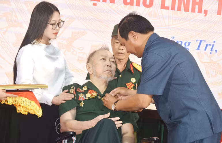 Đồng chí Võ Văn Hưng đeo huy hiệu Anh hùng lực lượng vũ trang nhân dân cho ông Dương Bá Quy.