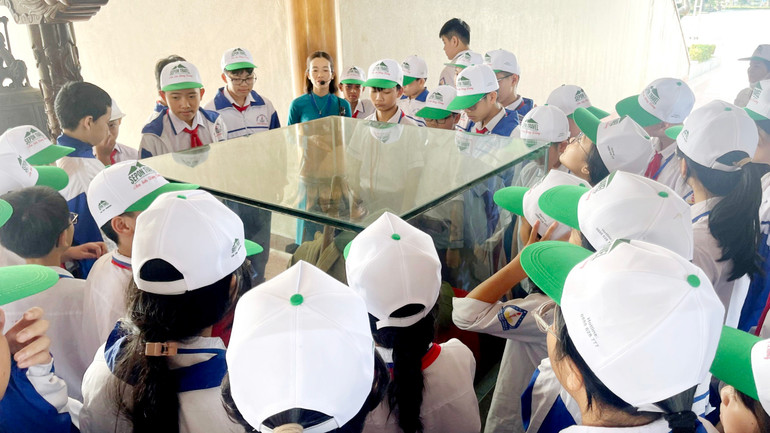 Các học sinh đang nghe hướng dẫn viên kể lại câu chuyện sự hy sinh anh dũng của chiến sĩ Thành Cổ Quảng Trị.