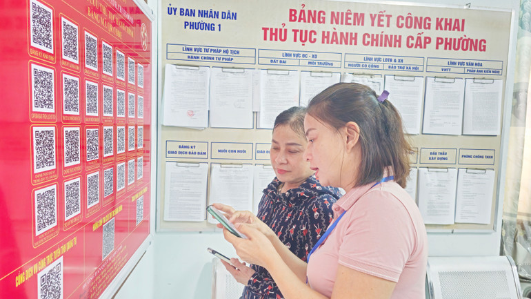 Cán bộ Phường 1, thành phố Đông Hà hướng dẫn người dân tra cứu thủ tục hành chính qua mã QR Code. Cán bộ Phường 1, thành phố Đông Hà hướng dẫn người dân tra cứu thủ tục hành chính qua mã QR Code.