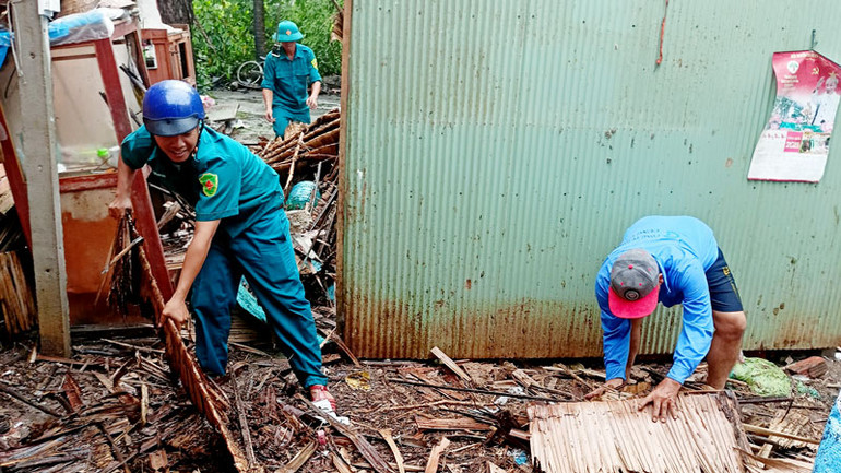 Bộ đội và dân quân giúp dân khắc phục hậu quả, ổn định nhà ở.